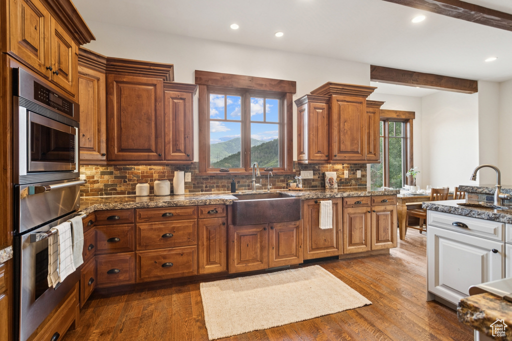 Kitchen with stainless steel oven, plenty of natural light, a warming drawer, tasteful backsplash, and recessed lighting