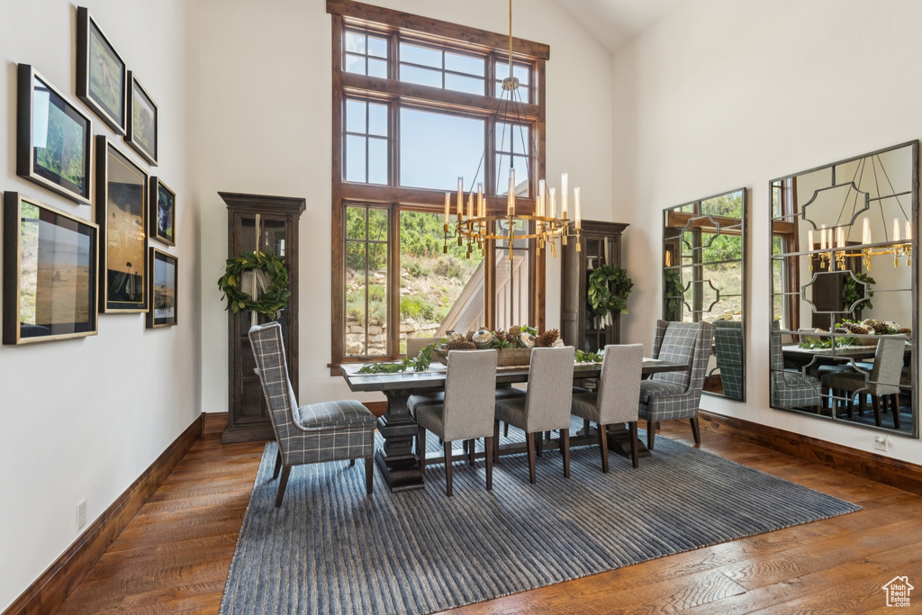 Dining room featuring a chandelier, high vaulted ceiling, and wood finished floors