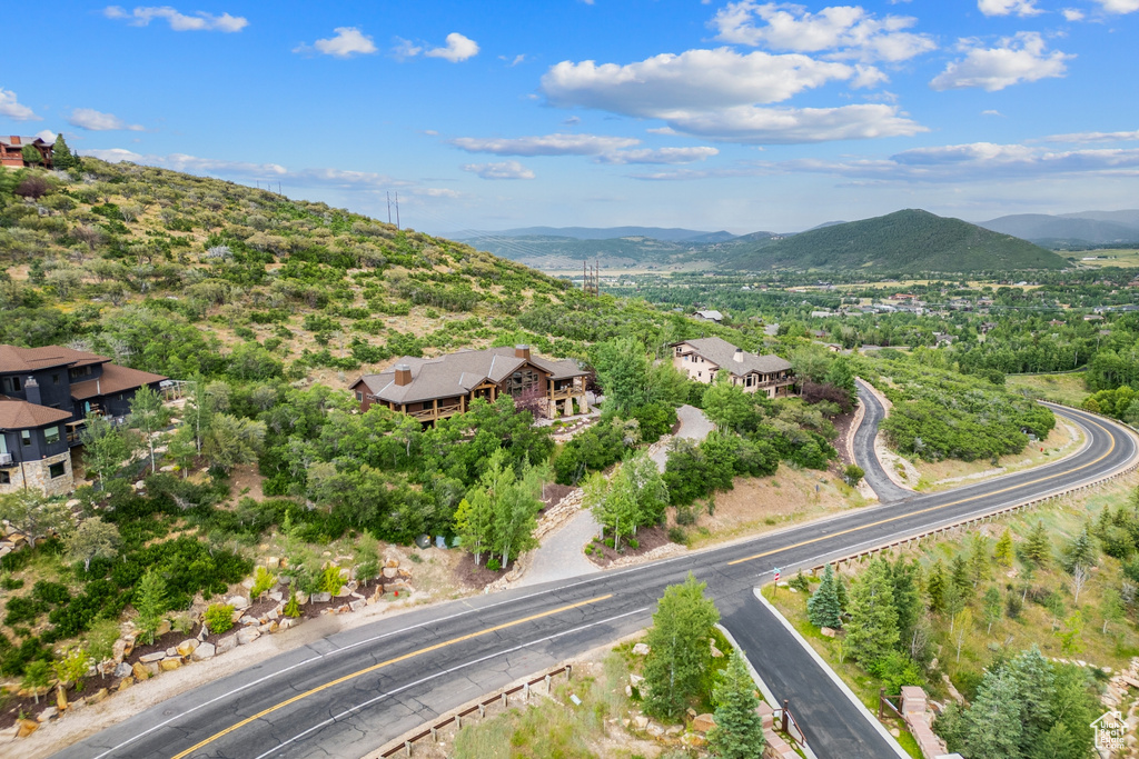 Aerial view of property and surrounding area featuring a mountain backdrop