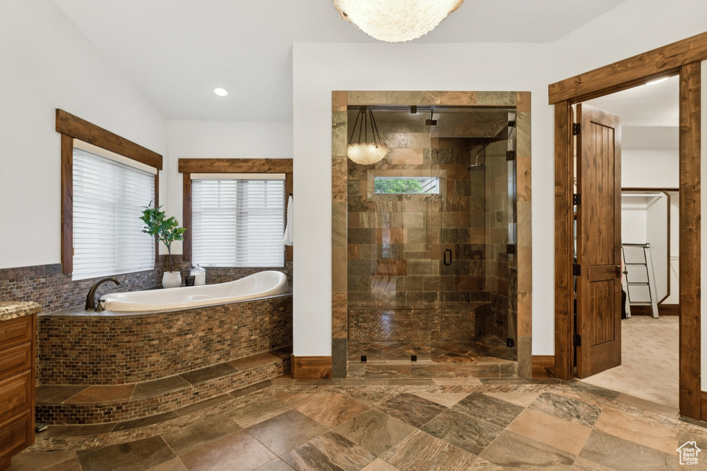 Full bath featuring a bath, a stall shower, and vanity