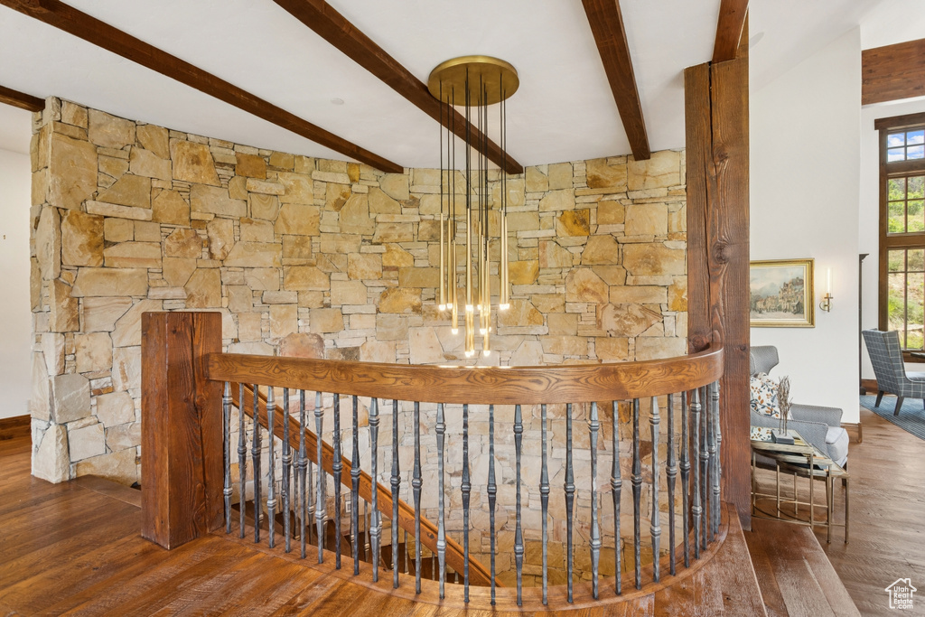 Staircase featuring beamed ceiling and wood finished floors