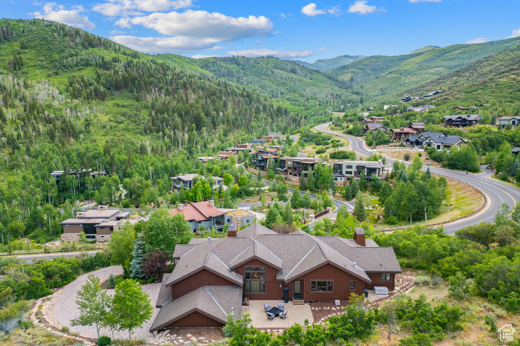 View from above of property with a mountainous background and a heavily wooded area