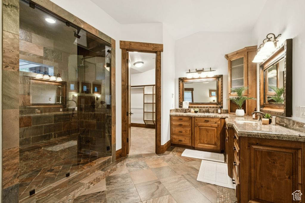 Full bathroom with a stall shower, vanity, and vaulted ceiling