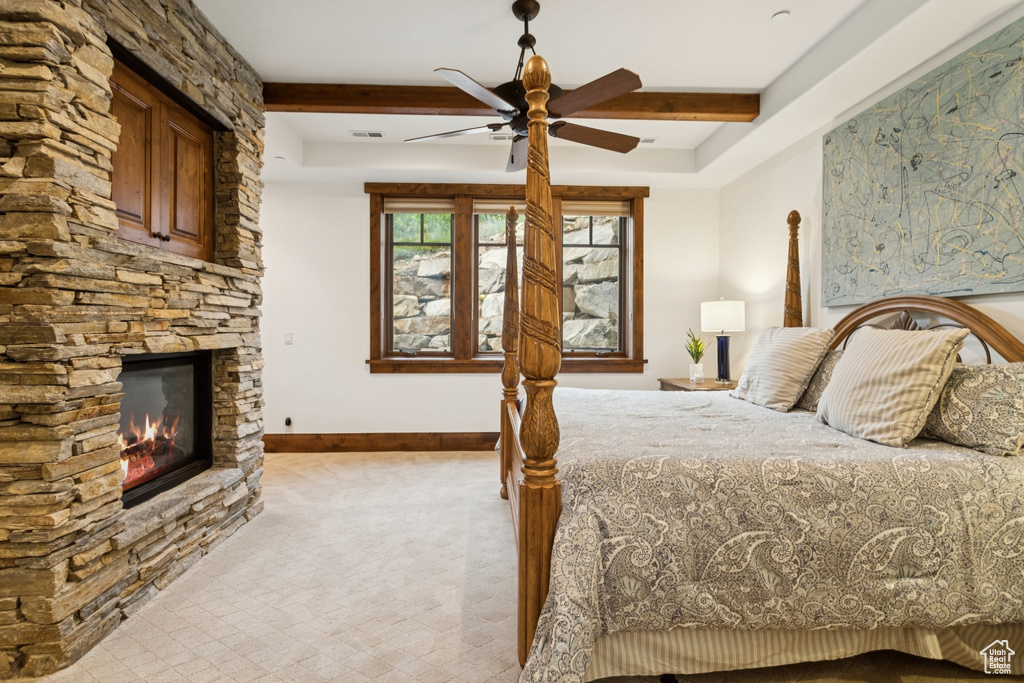 Bedroom featuring a fireplace, carpet floors, beamed ceiling, and a ceiling fan