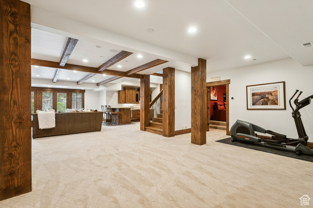 Living area with stairway, recessed lighting, light colored carpet, and beam ceiling