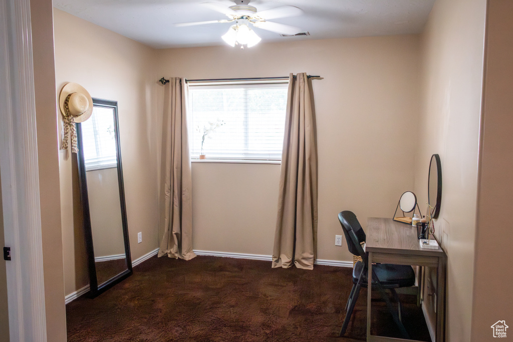Office space with ceiling fan and dark colored carpet