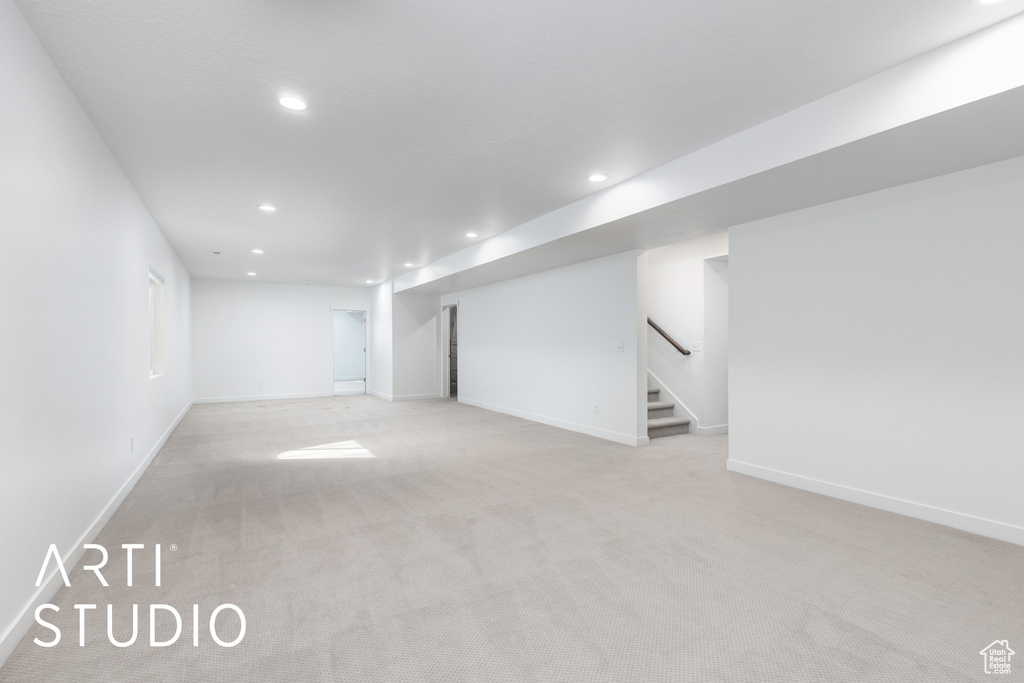 Finished basement with recessed lighting, light carpet, and stairs