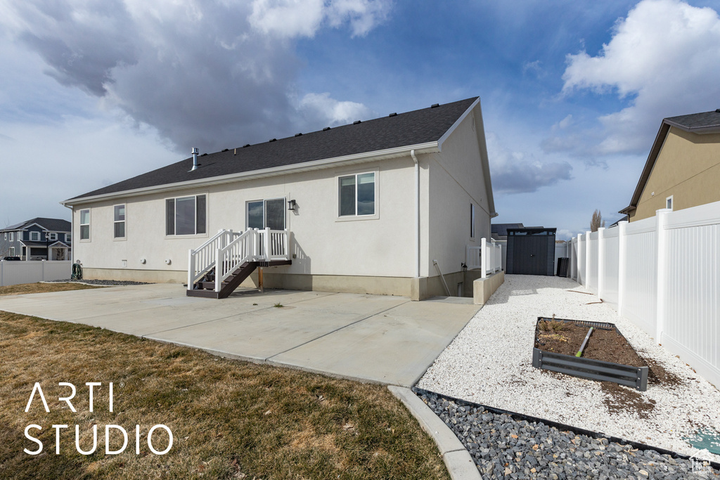 Back of house with a patio area and stucco siding