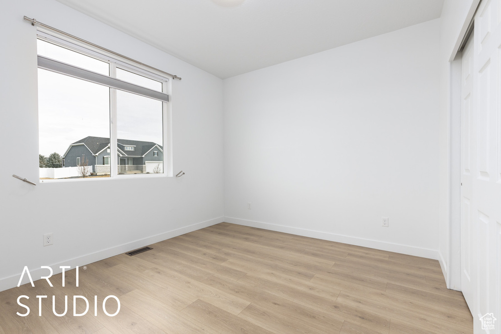 Unfurnished bedroom featuring light wood-type flooring and a closet