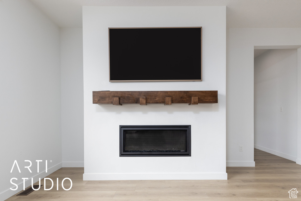 Detailed view of wood finished floors and a glass covered fireplace