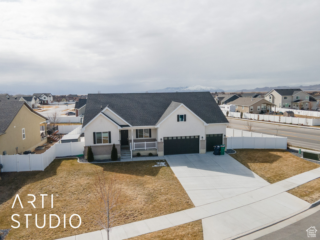 View of front facade with a residential view, a shingled roof, driveway, stucco siding, and an attached garage