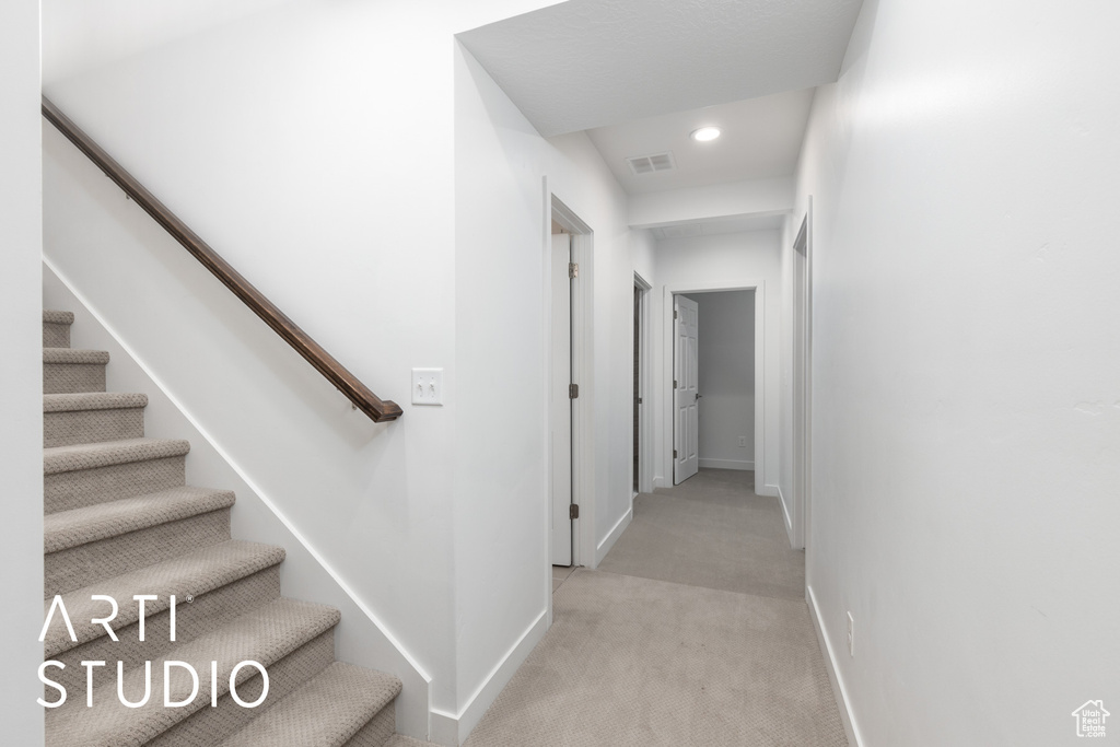 Corridor featuring light colored carpet, stairway, and recessed lighting