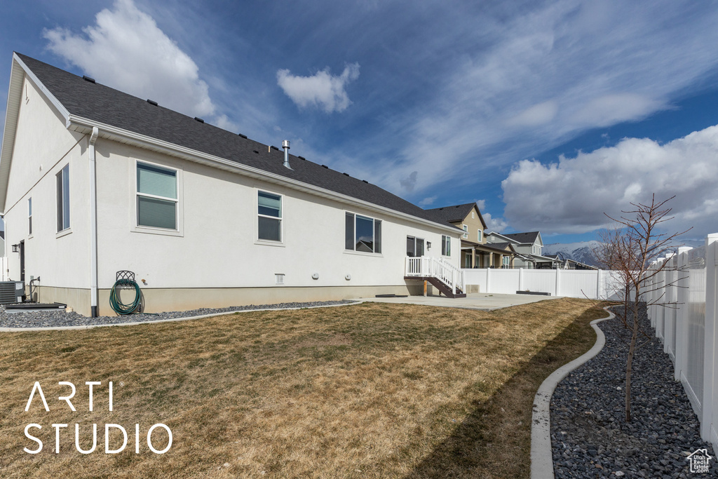Rear view of house featuring a fenced backyard and stucco siding