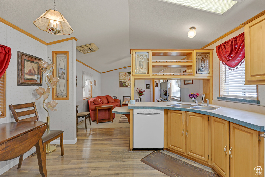 Kitchen featuring dishwasher, ornamental molding, lofted ceiling, light wood-type flooring, and a peninsula