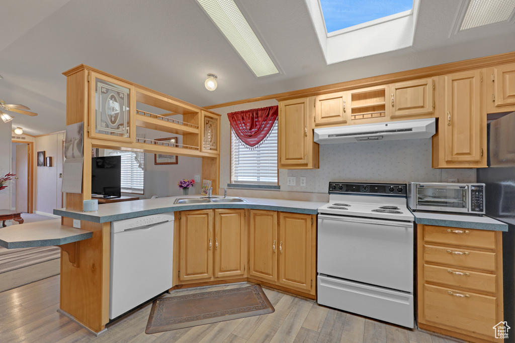 Kitchen with white appliances, ventilation hood, open shelves, and a peninsula