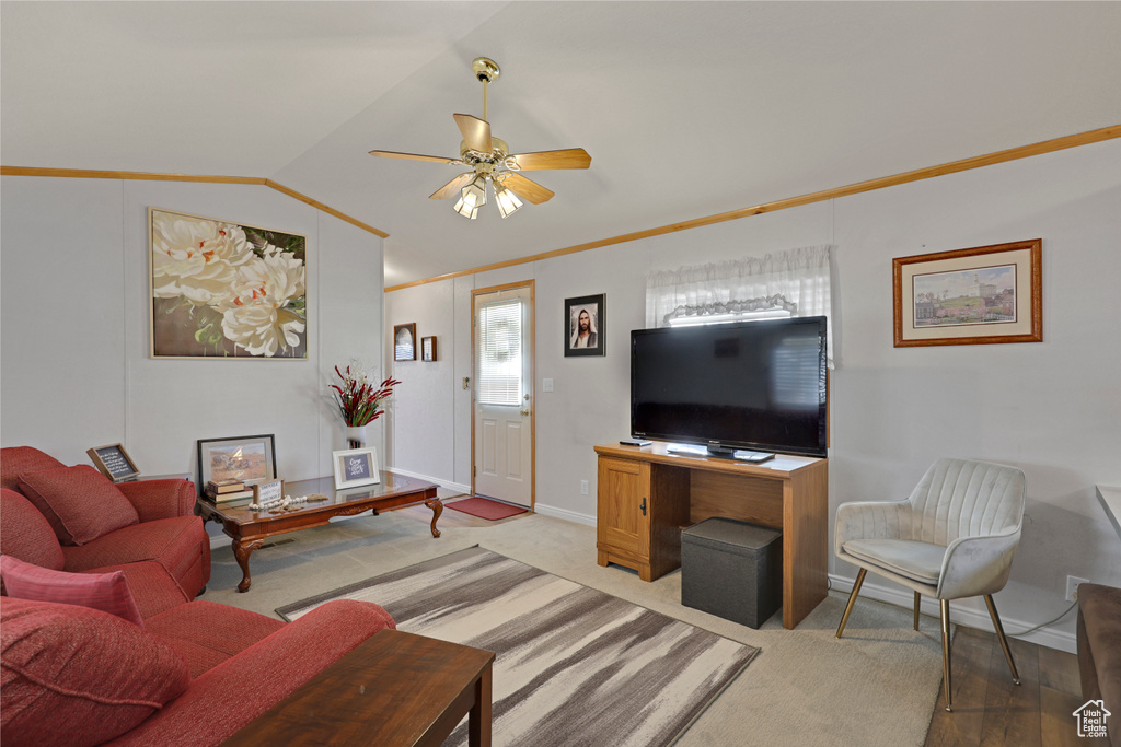 Living area featuring lofted ceiling, a ceiling fan, and ornamental molding