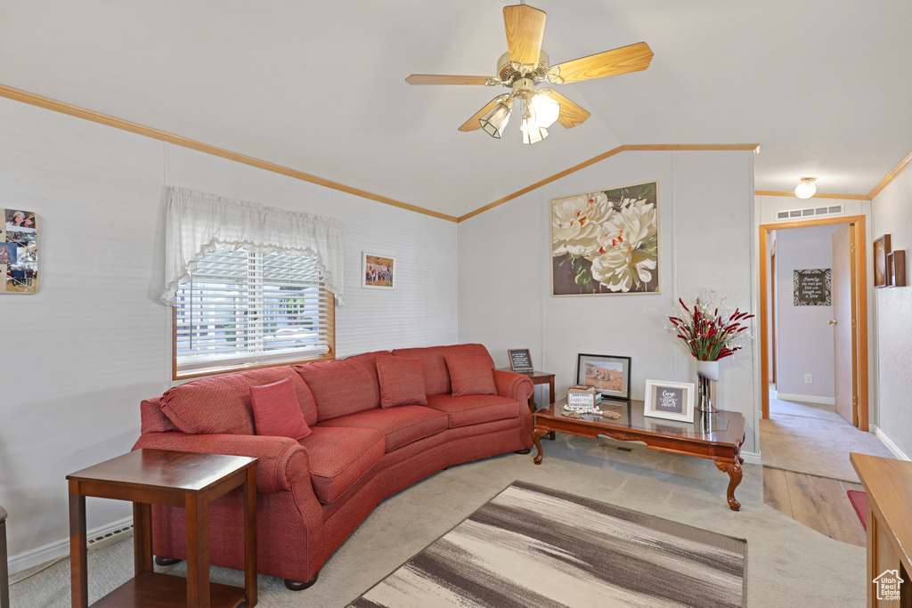 Living room with carpet, ornamental molding, vaulted ceiling, and a ceiling fan