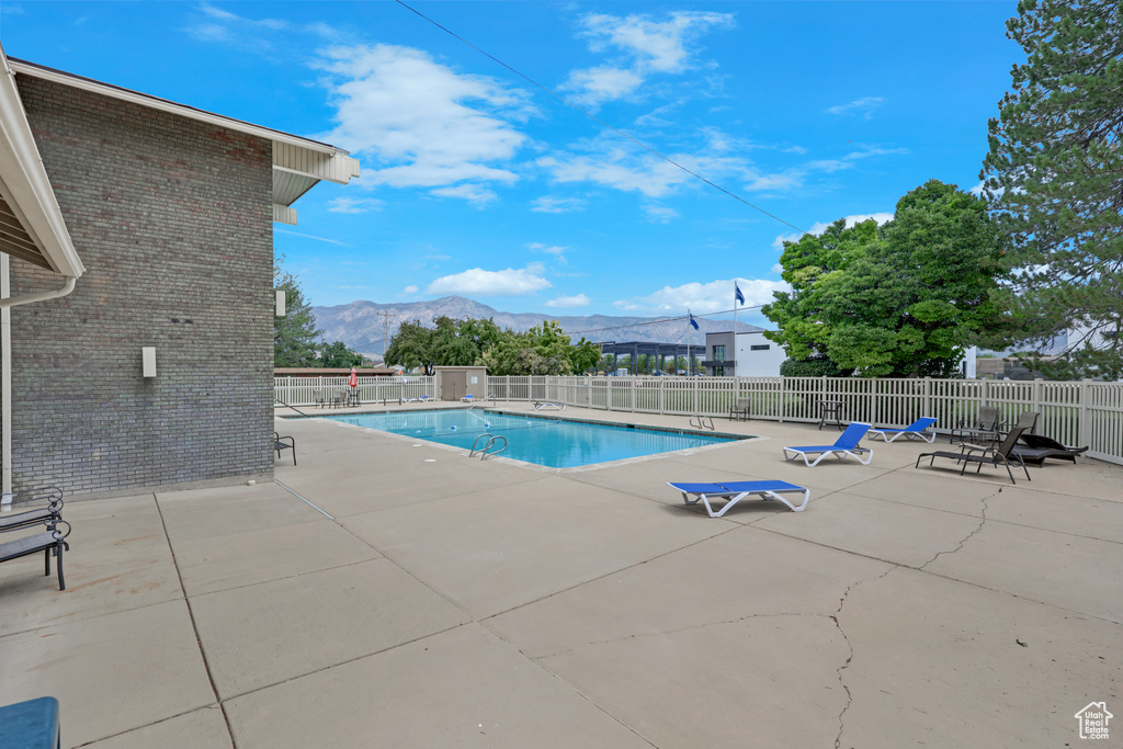 Community pool with a mountain view and a patio area