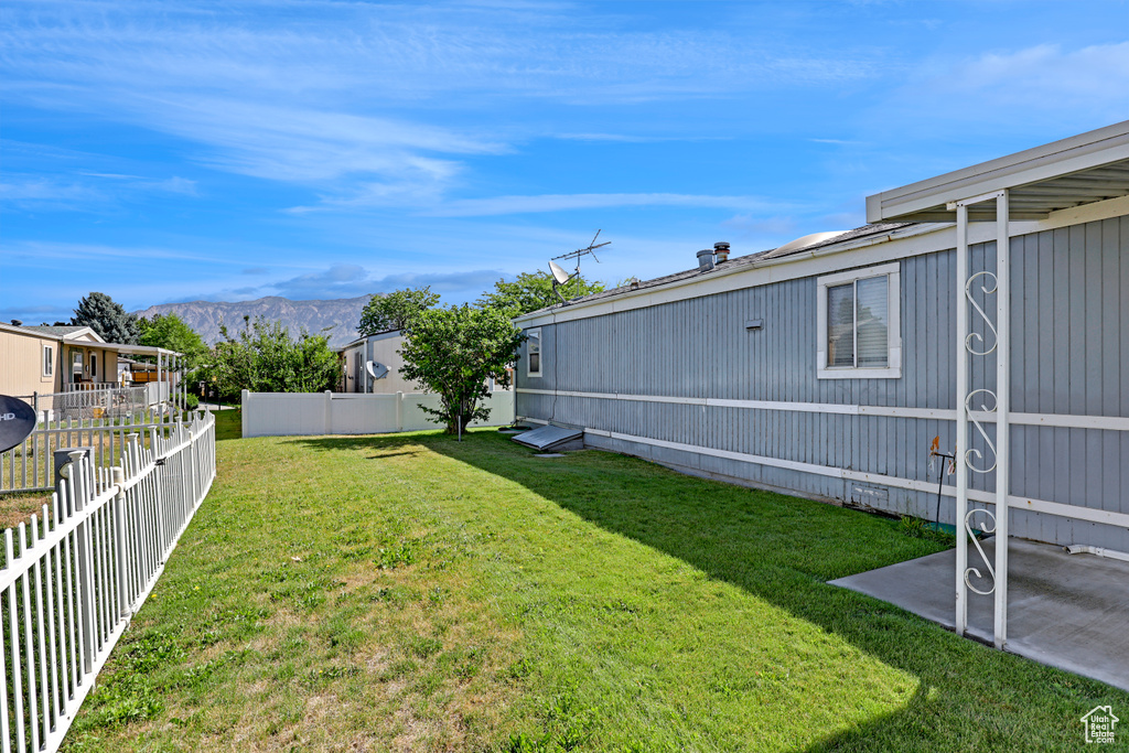 Fenced backyard featuring a mountain view and a patio area