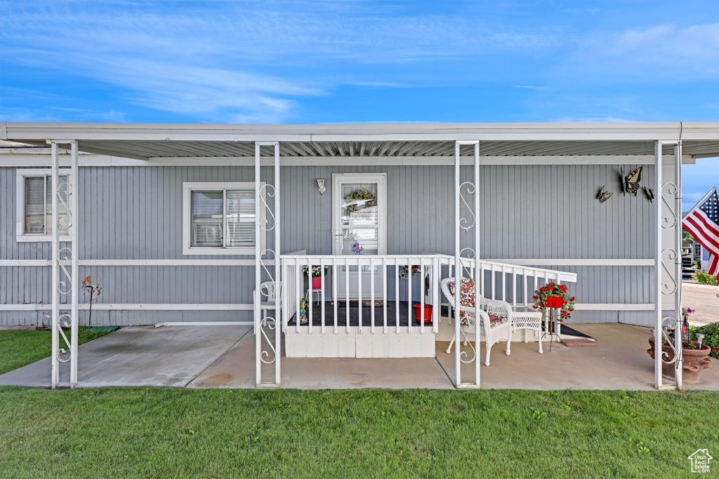 Back of property with covered porch and a yard