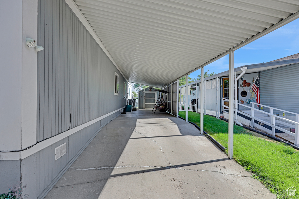 View of patio with a storage unit and an attached carport