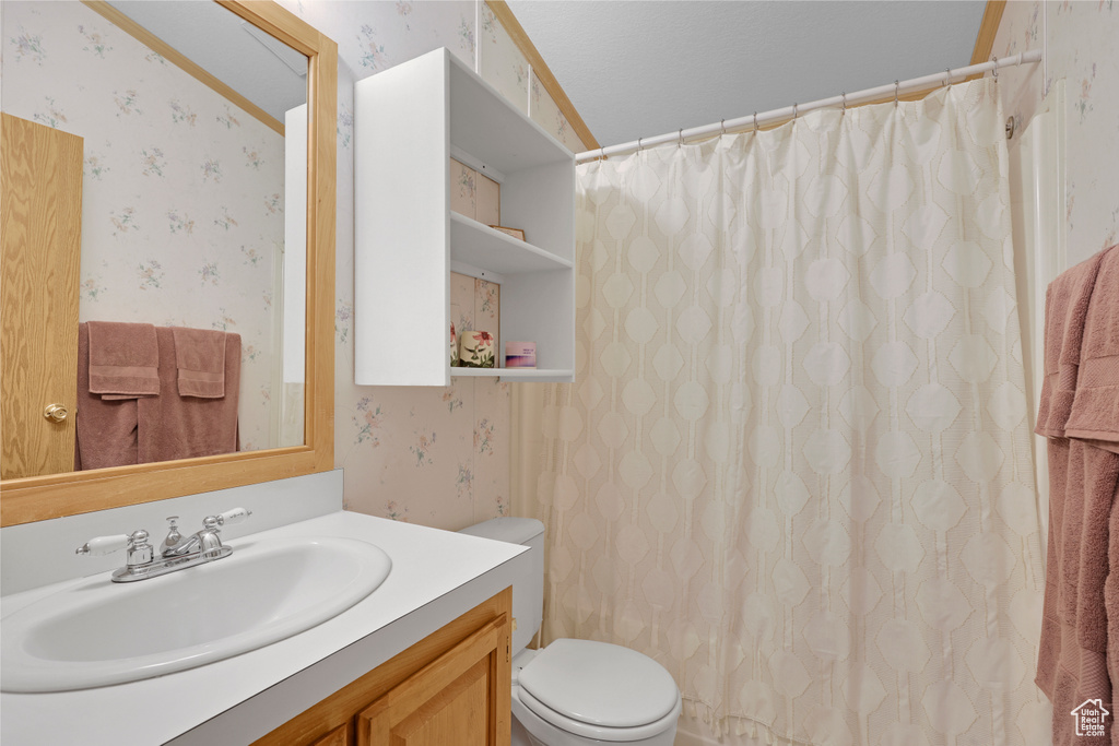 Full bath featuring wallpapered walls, vanity, and a shower with shower curtain