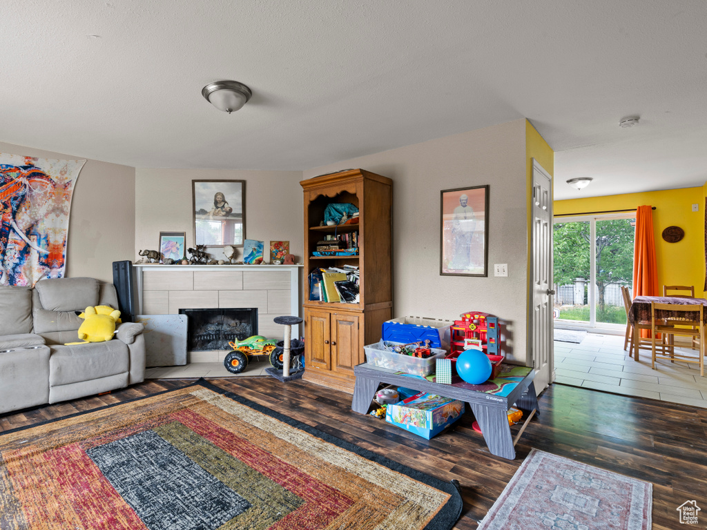 Living area with wood finished floors and a tiled fireplace