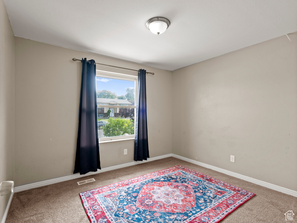 Carpeted spare room with baseboards