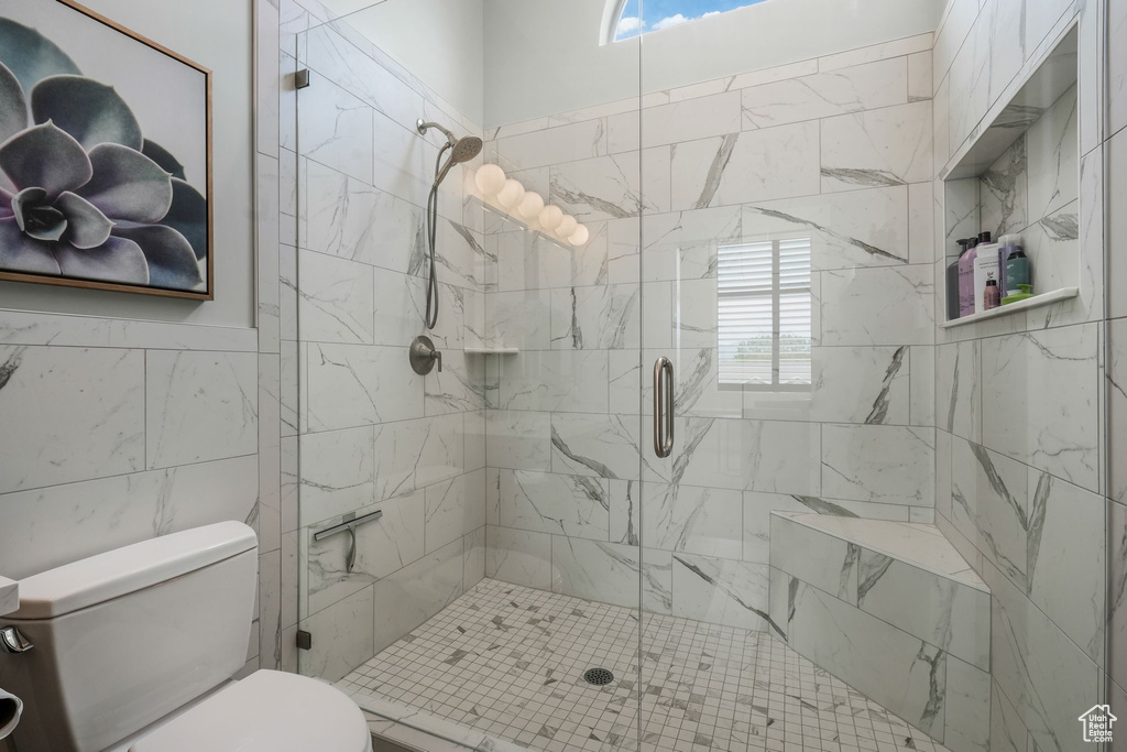 Bathroom with a shower stall and tile walls