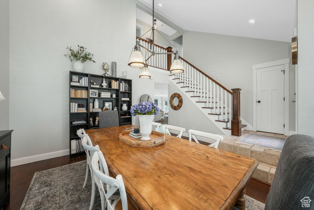 Dining room featuring stairway, high vaulted ceiling, and wood finished floors