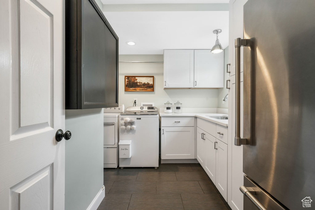 Kitchen featuring freestanding refrigerator, washing machine and clothes dryer, white cabinetry, recessed lighting, and light countertops