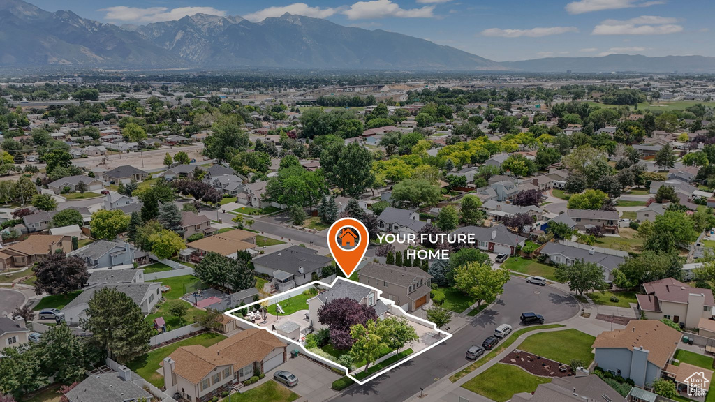 Aerial view of residential area with a mountainous background and property parcel outlined