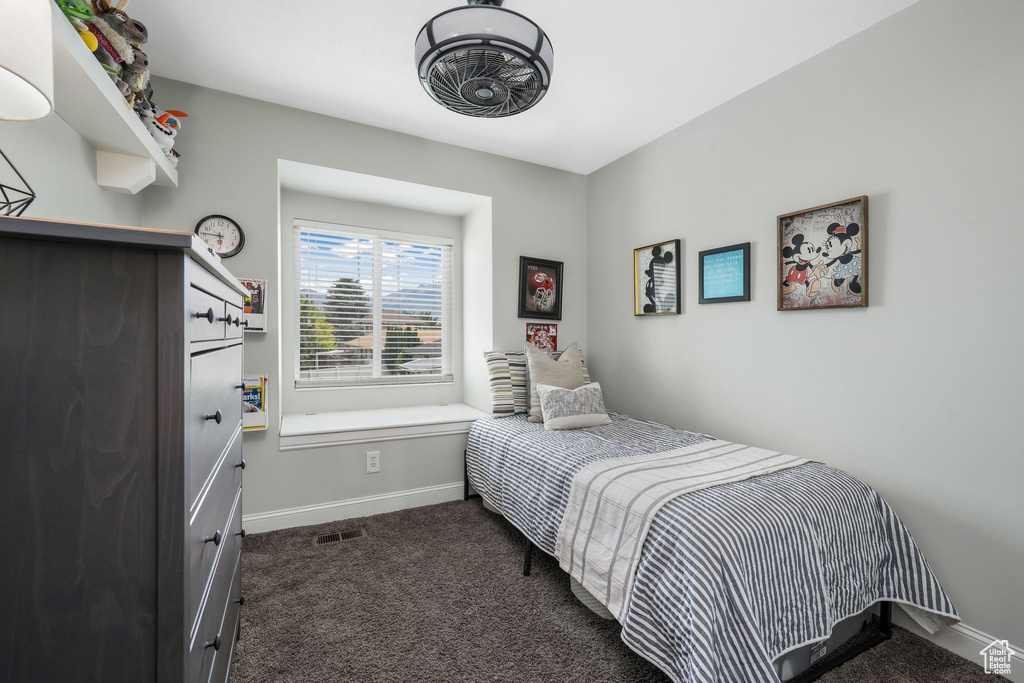 Bedroom with dark colored carpet and baseboards