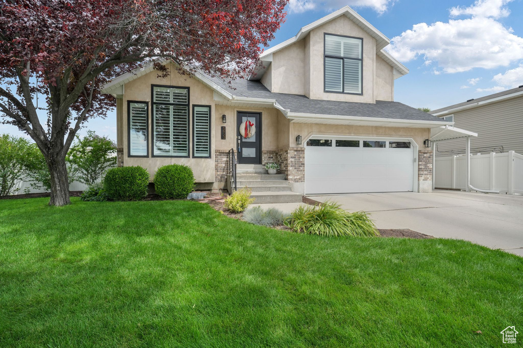 View of front of property featuring stucco siding, driveway, an attached garage, and a shingled roof