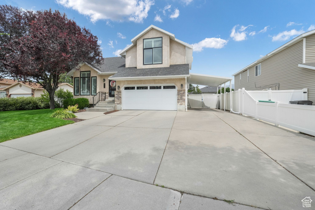 Traditional home featuring driveway, a garage, stucco siding, and roof with shingles