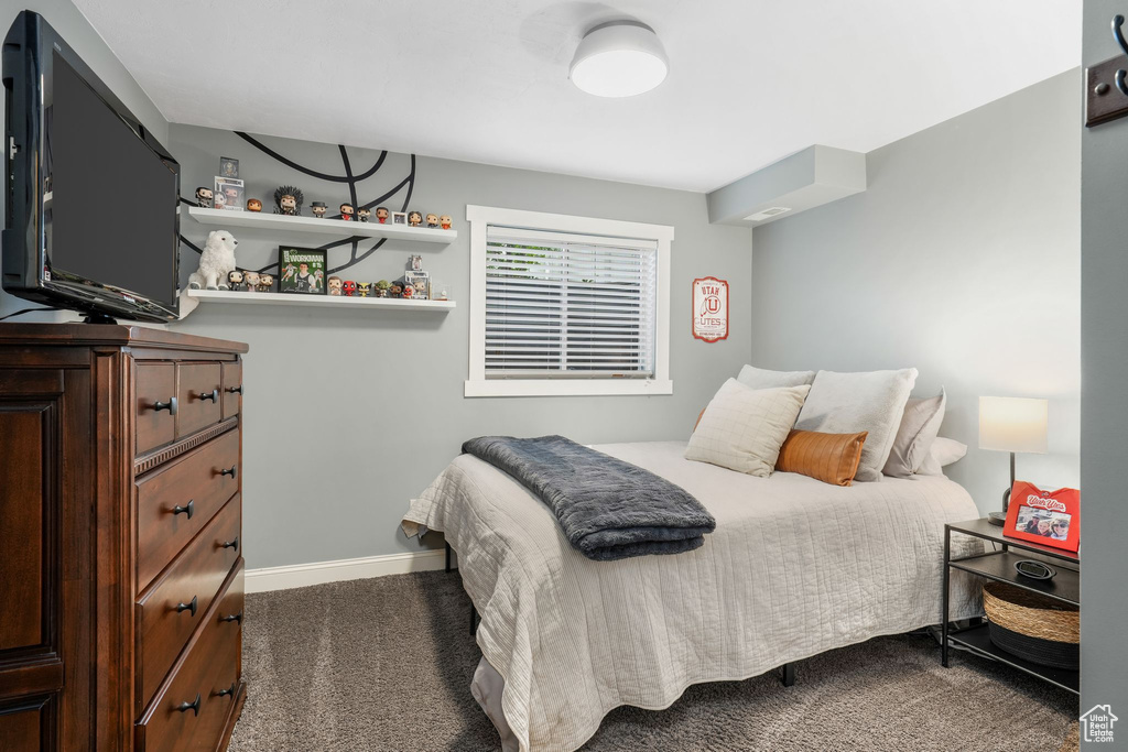 Bedroom with dark colored carpet and baseboards