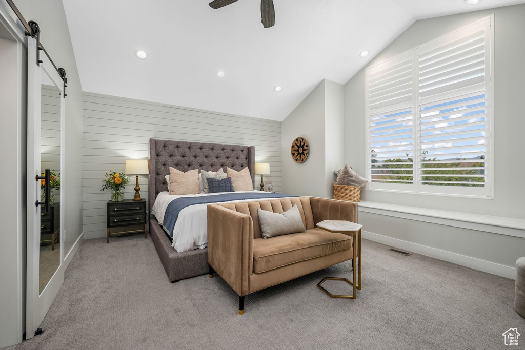 Bedroom featuring a barn door, light carpet, vaulted ceiling, recessed lighting, and ceiling fan