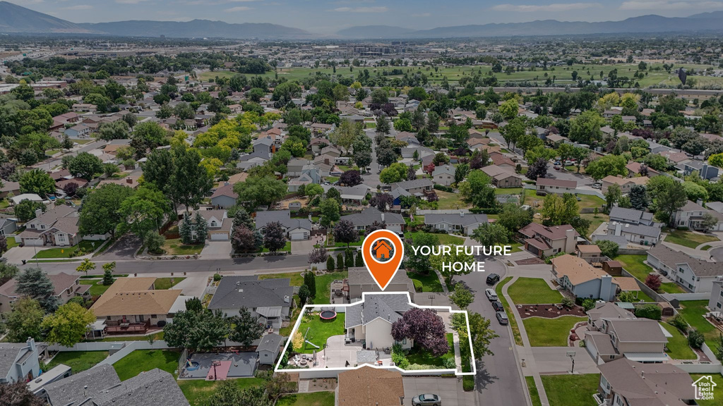 Aerial view of residential area with a mountainous background and property boundaries highlighted