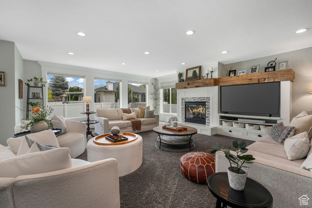 Living area featuring healthy amount of natural light, recessed lighting, a large fireplace, and carpet flooring