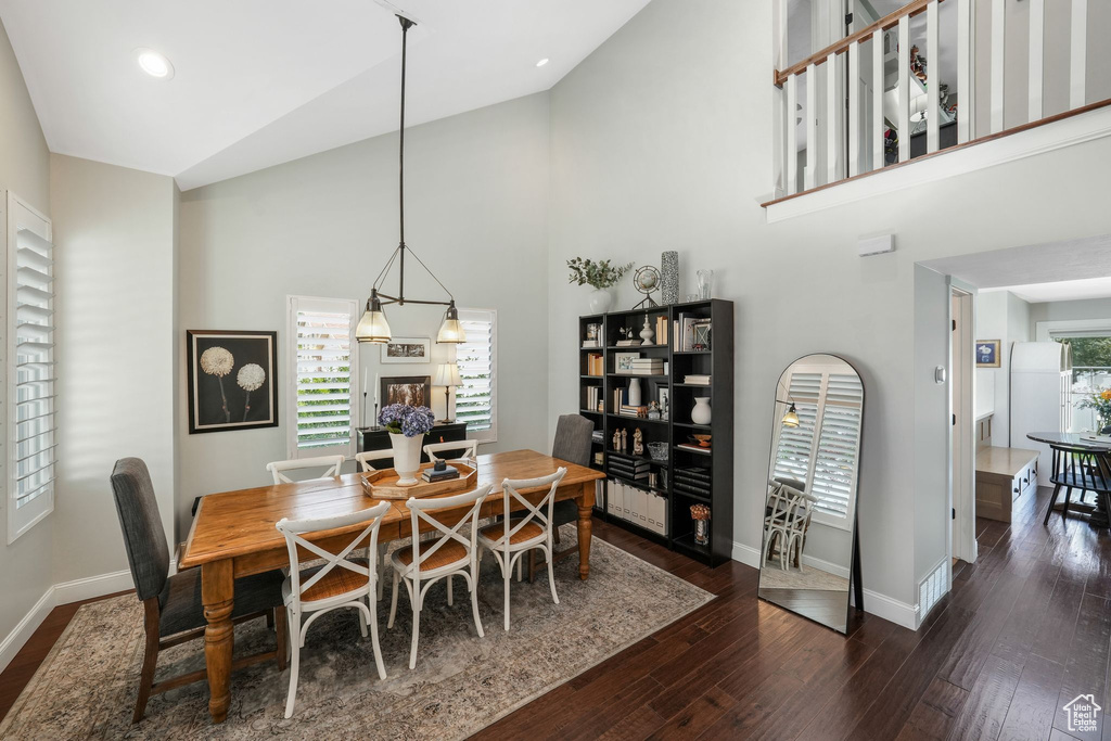 Dining room with high vaulted ceiling and wood finished floors