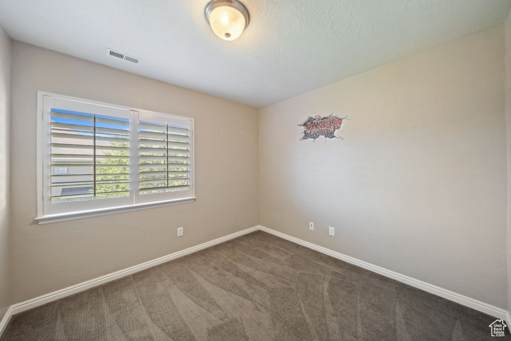 Carpeted empty room featuring baseboards