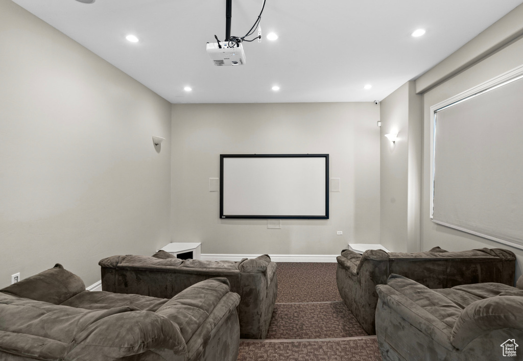 Home theater with dark colored carpet and recessed lighting