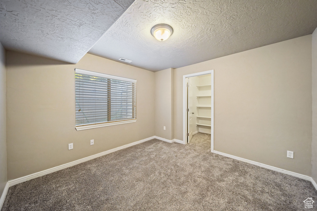 Spare room with carpet flooring and a textured ceiling