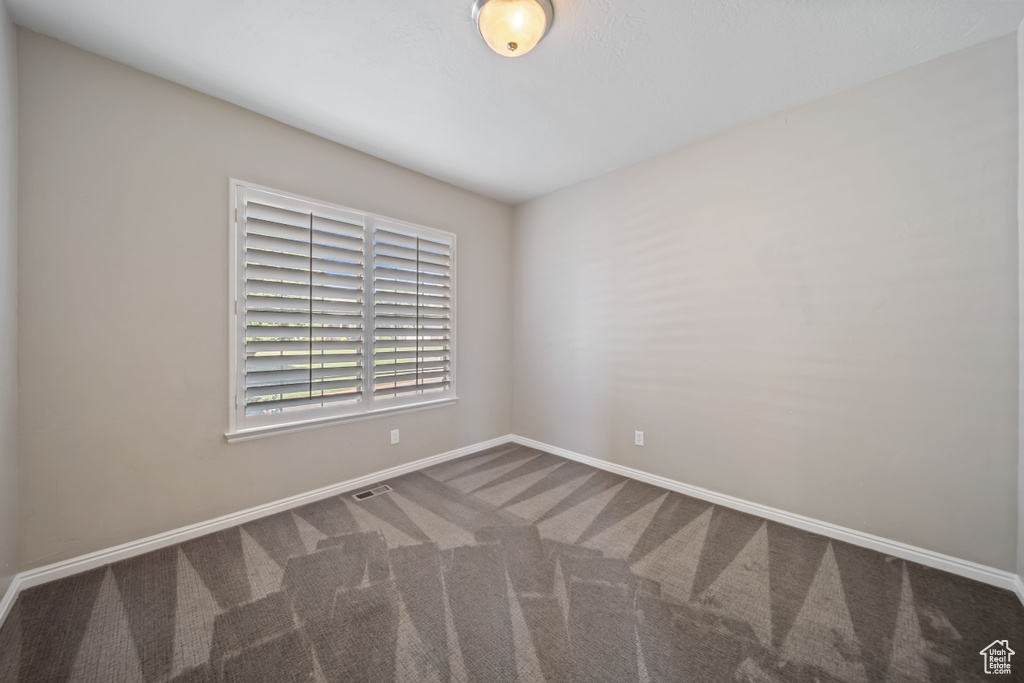 Carpeted spare room with baseboards