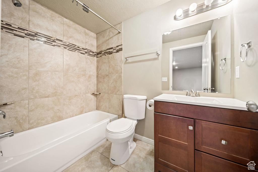 Full bath with bathtub / shower combination, vanity, tile patterned floors, and a textured ceiling