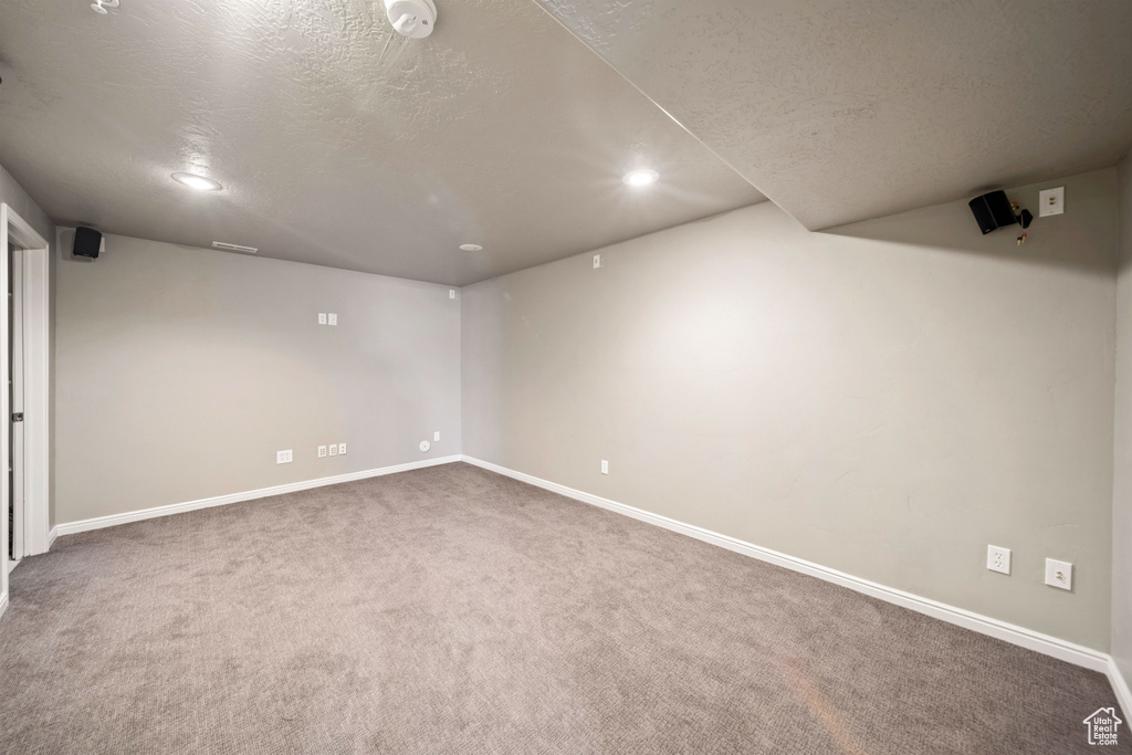 Finished below grade area with carpet flooring, recessed lighting, and a textured ceiling