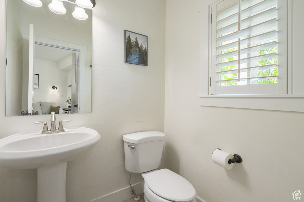 Half bath featuring toilet and baseboards