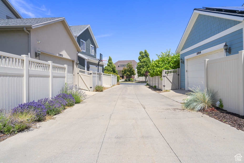 View of concrete road featuring a gate and a residential view