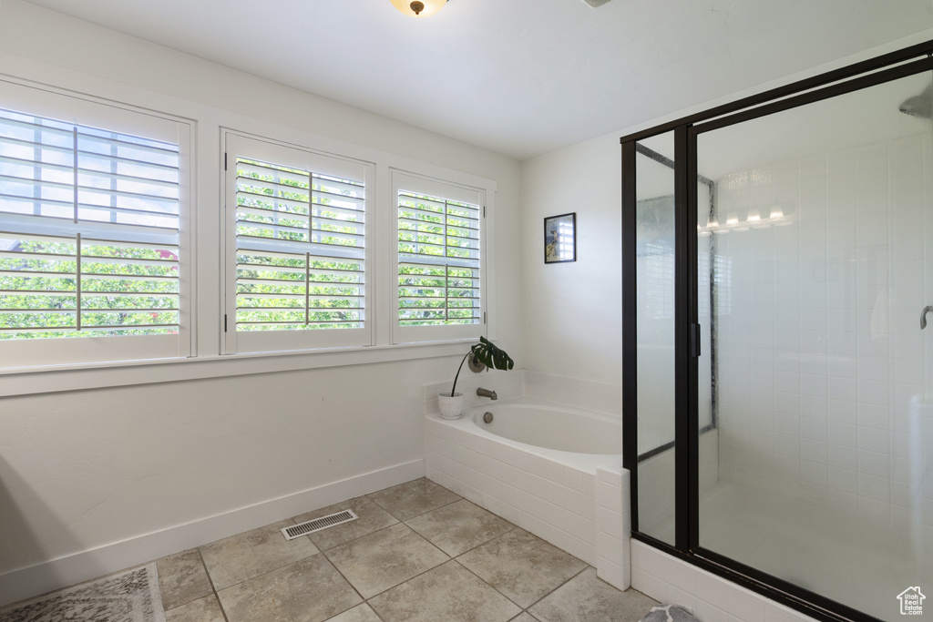 Bathroom featuring a garden tub, tile patterned flooring, and a stall shower