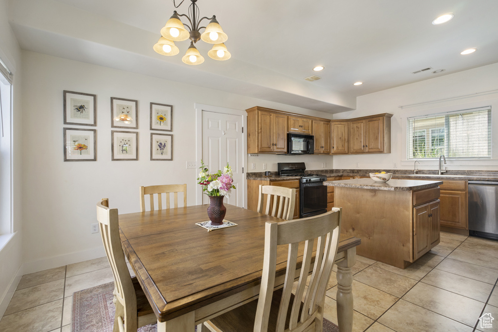 Dining area with light tile patterned flooring, a chandelier, and recessed lighting
